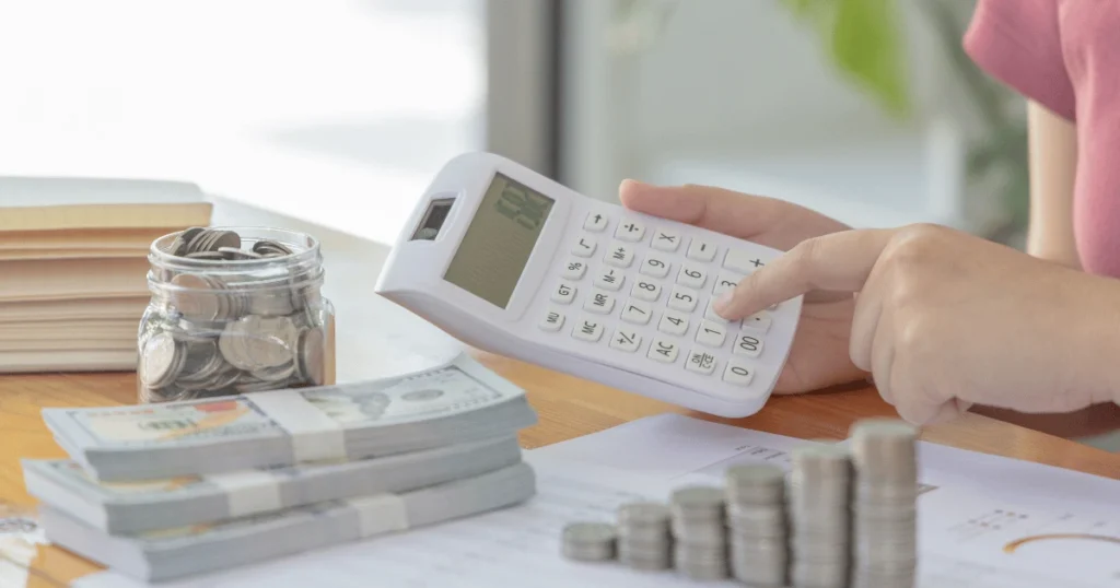 Henkilö käyttää alv laskuri -työkalua tietokoneella laskeakseen verollisen ja verottoman hinnan.