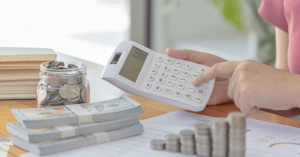 Henkilö käyttää alv laskuri -työkalua tietokoneella laskeakseen verollisen ja verottoman hinnan.